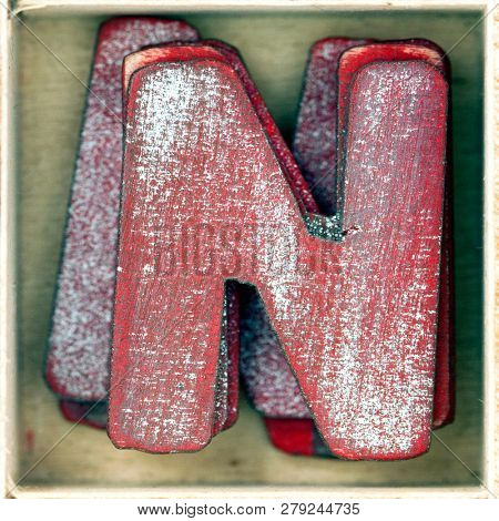 old wooden letter N in a box shot from above macro image 