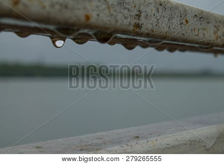 Hanging Drops Of Water On The Rusty Railing After The Spring Rain In An Abandoned Place Near The Riv