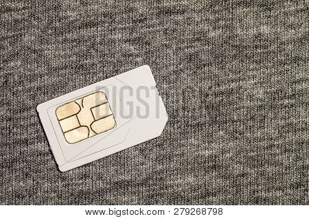 Simcard Isolated On Grey Cloth Texture Background