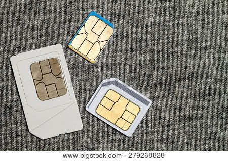 Set Of Mini, Micro And Nano Simcard. Isolated On Grey Cloth Texture Background