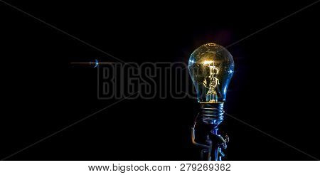 Cosmic Explosion Of A Burning Light Bulb With Flying Splinters And Smoke On A Black Background With