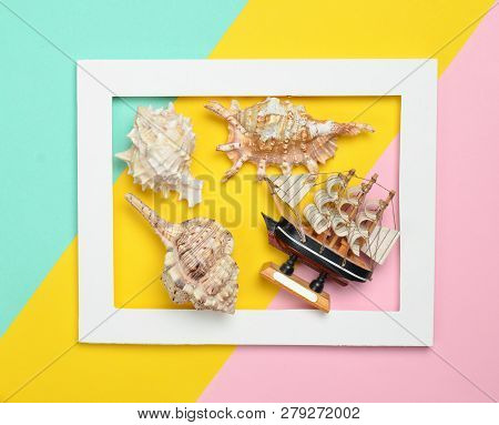 Seashells And Decorative Wooden Ship In A White Rectangular Frame On A Colored Pastel Background. Mi