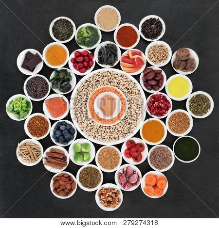 Large health food wheel with foods to slow the ageing process down. Very high in antioxidants, anthocyanins, dietary fibre and vitamins. On slate background top view.