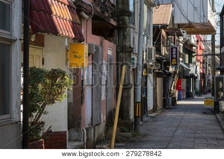 Beppu, Japan - November 3, 2018: Small street in the centre of the city of Beppu with signs and lots of electricity wires