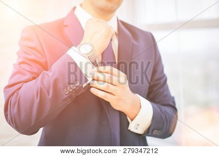 Close-up Of Man In Suit With Watch On His Hand Fixing His Cufflink. Groom Bow Tie Cufflinks.