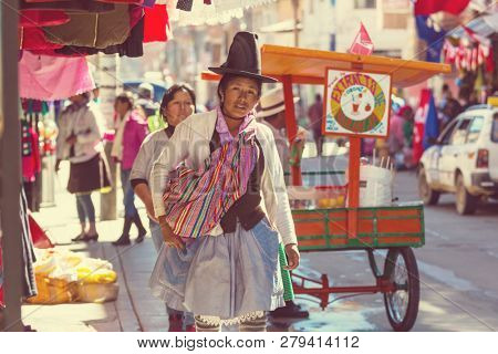 HUARAZ, PERU - JULY 27: Traditionally dressed peruvian people sell fruits and vegetables on the street market on July 27, 2017 in Huaraz, Peru.