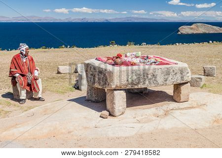 Isla Del Sol, Bolivia - May 12, 2015: Native Man In Traditional Clothing Next To The Ceremonial Tabl