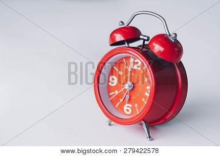 Red Alarm Clock On White Table.time Management And Punctuality At Work Concept.