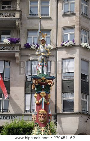 LUCERNE, SWITZERLAND - JUNE 24, 2018: Knight with flag and a sword of Fritschi Fountain, built in 1918 and dedicated to a legendary Carnival's character in Lucerne, Switzerland