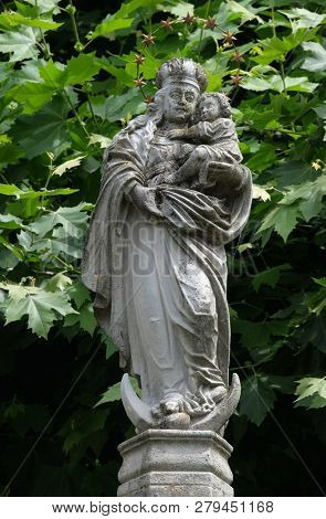 LUCERNE, SWITZERLAND - JUNE 24, 2018: The statue of the Virgin Mary with the child Jesus in the courtyard of the church of St. Leodegar in Lucerne, Switzerland
