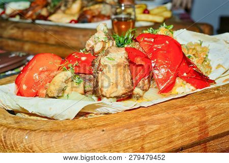 A Wooden Dish With Grilled Ribs, Mushrooms, And Stewed Cabbage, Decorated With Poedors And Baked Pep