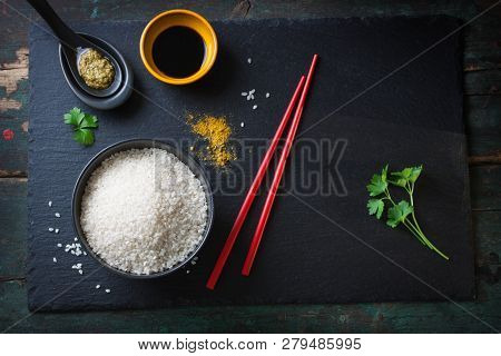 Composition With Asian Food - Rice For Sushi, Spices, Sauces And Chopsticks On A Wooden And Stone Ba