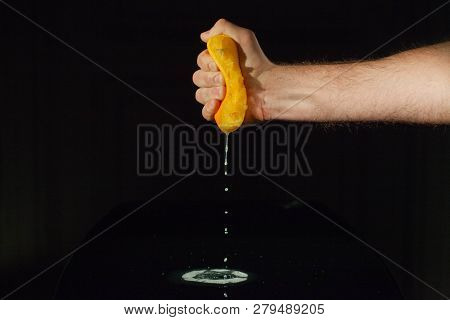 Orange Juice Splashes From Half Of Fruit In Man's Hand