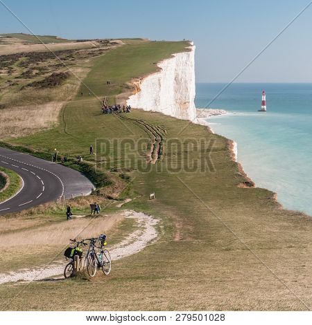 A View Over The South Downs Towards Beachy Head And Its Lighthouse With A Pair Of Bicycles Left By T