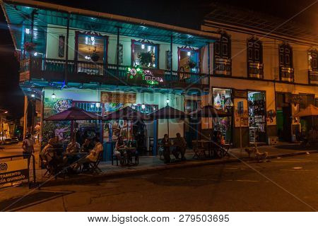 Filandia, Colombia - September 6, 2015: People Sit By The Pub Tables On A Street Of This Touristic V