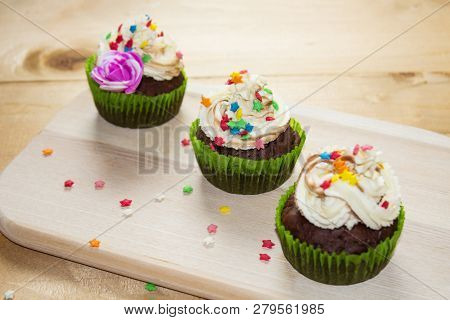 Muffins On A Wood Cutting Board. Cream Decoration. Place For Text.