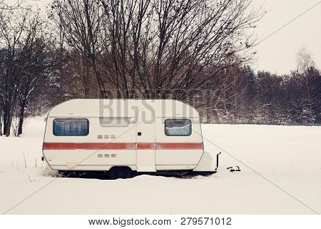 Camper Caravan On The Snowy Winter Field