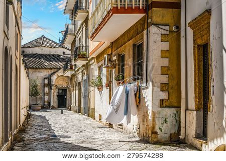 A Small Residential Alley With Laundry Hanging From A Window Leads To The Entrance Of The Church Of 
