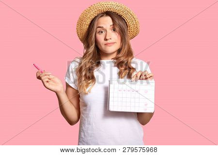 Hesitant Young Lady Carries Menstruation Period Calendar, Has Clueless Expression, Wears Headgear An