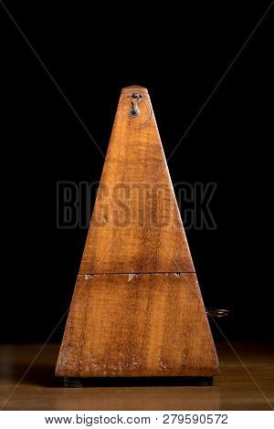 Detail Of An Old Mechanic Musical Metronome, Closed Lid, Black Background