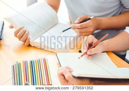High School Or College Students Studying And Reading Together In Library