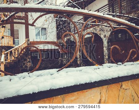 Srone Gate With Decorative Steel Trim. Snowfall On The Street.noon.