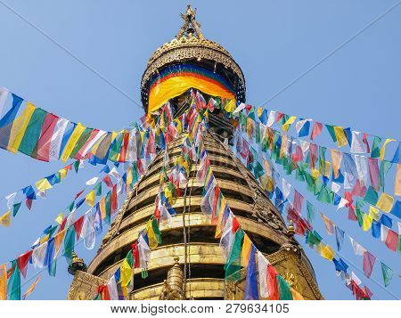 Spire Of Thirteen Tiers And Tip Among Prayer Flags In Upper Part Of The Swayambhunath Stupa On A Bac