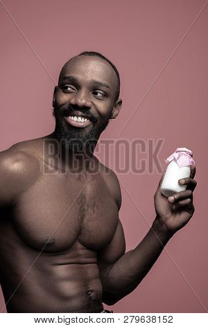 Healthy Young African Man Holging Little Bottle Of Milk On A Pink Studio Background. Close Up Portra