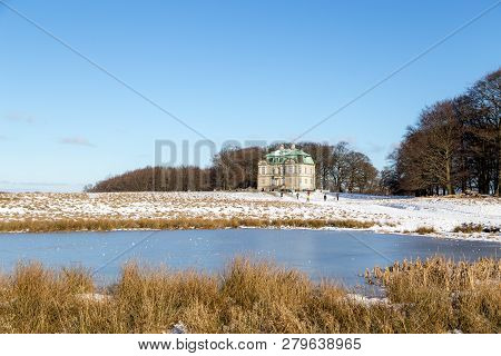 Klampenborg, Denmark - February 12, 2017: The Hunting Lodge And People Walking In The Snowy Deer Par