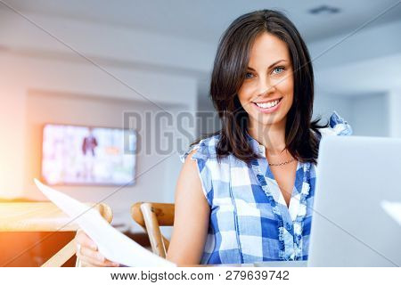 Woman with papers in their living room