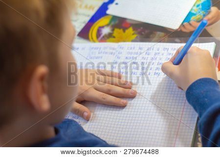 Home Education And Work After School. Boy Hand With Pen Writing English Test By Hand On Traditional 