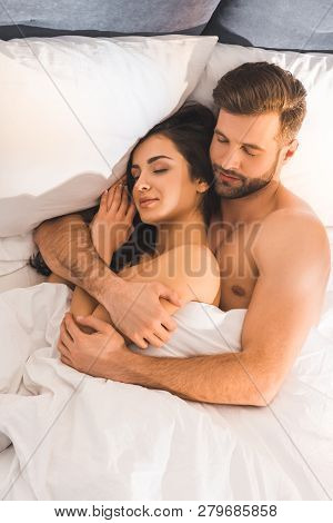 Beautiful Nude Couple Embracing While Sleeping In Bed