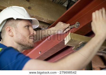 Construction Worker Fitting Steel Support Beam Into Renovated House Ceiling