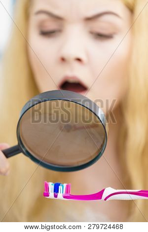 Beautiful Perfectionist Young Woman Checking Her Tooth Brush Through Manifying Loupe Glass. Hygiene,
