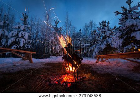 Bonfire In The Winter Forest Illuminates The Snow. Kareliya, Winter.