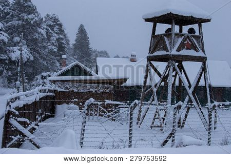 A Watchtower With The Fence In The Middle Of The Snow Covered Forest.