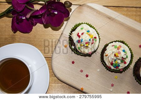 Muffins On A Wood Cutting Board. Cream Decoration. Tea. Place For Text.