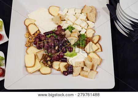 Mixed Cheese Slices With Snacks On The White Plate