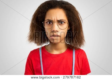 Student Girl Poses Alone Against White Background In Studio. Photo Of Nervous Young African American