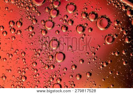 Macro Shot Of Backlit Gas-liquid Emulsion Over Colored Background. Tiny Gas Bubbles Inside Larger Oi