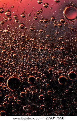 Macro Shot Of Backlit Gas-liquid Emulsion Over Colored Background. Tiny Gas Bubbles Inside Larger Oi