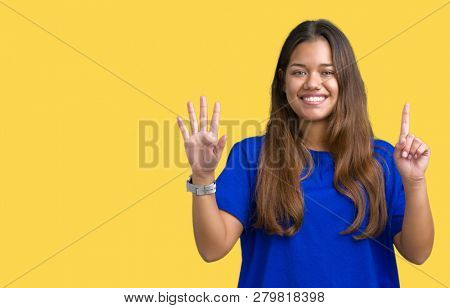 Young beautiful brunette woman wearing blue t-shirt over isolated background showing and pointing up with fingers number six while smiling confident and happy.