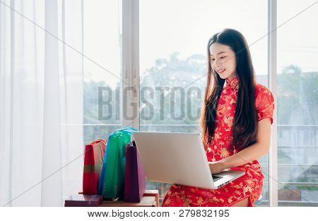 Beauty Asian Woman With Chinese Dress,qipao,cheongsam Chinese New Year Using Laptop Computer Shoppin