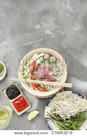 Traditional Vietnamese Soup Pho Bo With Herbs, Meat, Rice Noodles, Broth. Pho Bo In Bowl With Chopst