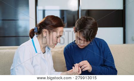 Woman Shows A Young Man A Hearing Aid.
