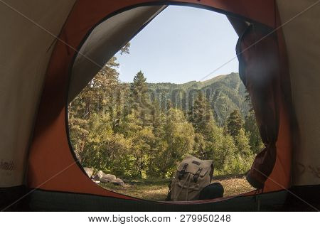 Camping In A Tent With Mountain Views. Backpack Near The Tent.