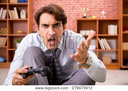 Young employee playing joystick games during his break 