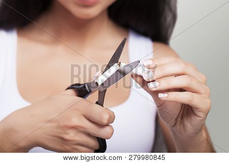 Stop Smoking The Concept. Young Beautiful Woman Cutting Cigarettes With Scissors Smiles, Isolated On