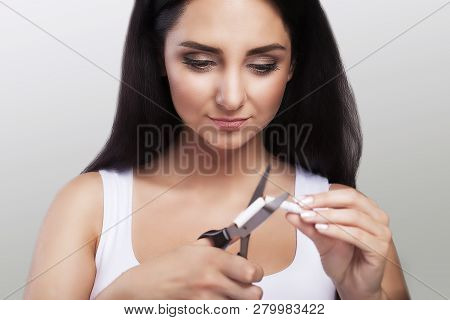 Stop Growing. Portrait Of A Beautiful Smiling Woman Holding Cigarettes And Scissors In Her Hands. Th
