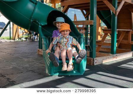 Two Boys Slid Down The Slide On The Playground